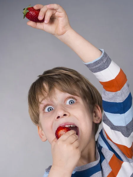 Miúdo bonito comendo morangos — Fotografia de Stock