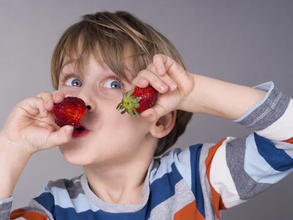 Schattige jongen eten aardbeien — Stockfoto
