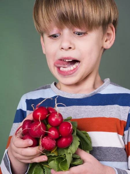 Mooie jongen houdt radijs en salade — Stockfoto