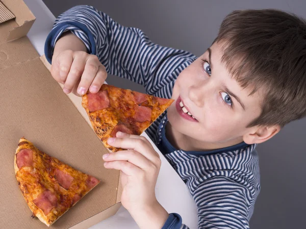 Junge isst gerne Pizza — Stockfoto