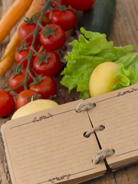 Legumes no fundo de madeira com notebook — Fotografia de Stock