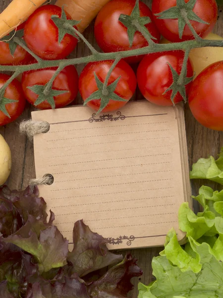Vegetables on the wooden background with notebook — Stock Photo, Image