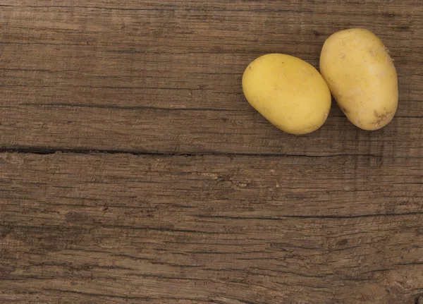 Batatas no fundo de madeira — Fotografia de Stock