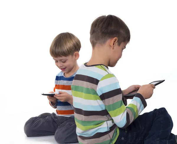 Мальчики играют в игры на планшетных компьютерах — стоковое фото