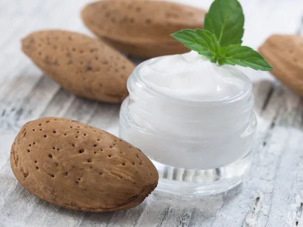 Facial cream and almonds — Stock Photo, Image