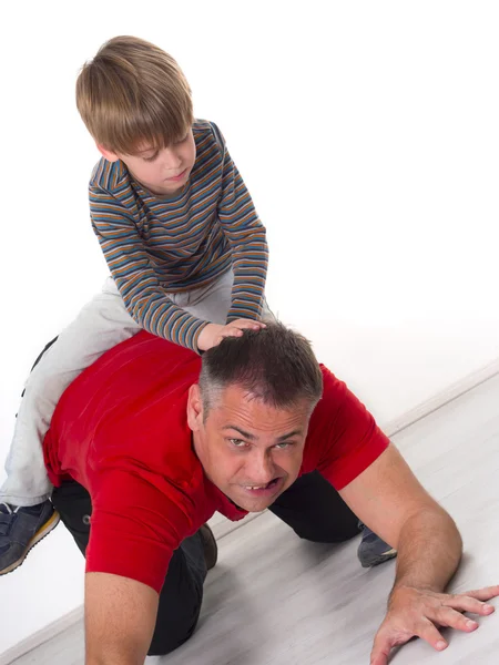 Zepsute dziecko na plecach ojca — Zdjęcie stockowe