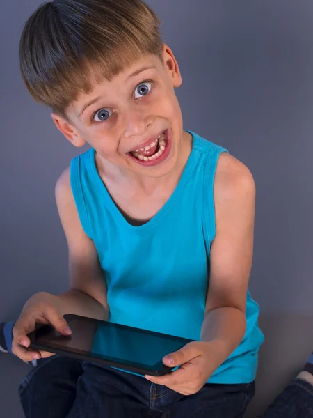 Мальчик играет в видеоигры на планшетном компьютере — стоковое фото