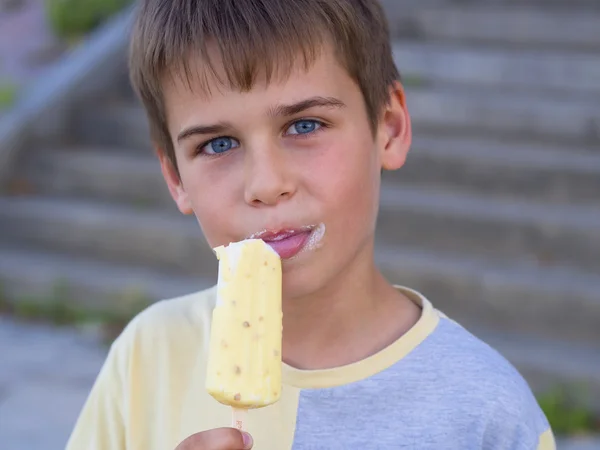 Χαριτωμένο αγόρι με μπλε μάτια, απολαμβάνοντας το παγωτό — Φωτογραφία Αρχείου