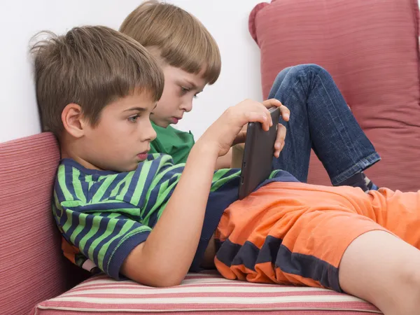 Schoolboys jogar jogos de vídeo em computadores de mesa — Fotografia de Stock