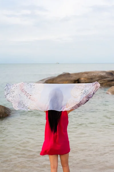 Mädchen mit Schal bei Wind am Strand — Stockfoto