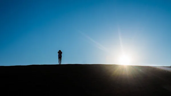 Silhouette von Menschen auf einem Hügel — Stockfoto