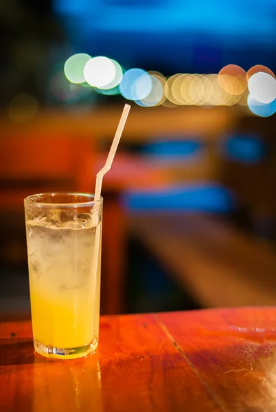 El jugo de naranja en la mesa wilth color de la luz — Foto de Stock