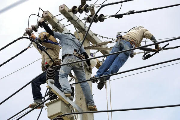 Team work electrician men on electric poles. — Stock Photo, Image