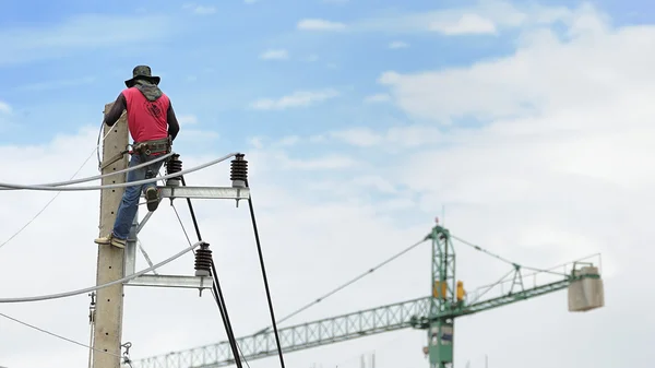 Elektriker man på elektriska poler電柱上の電気技師の男. — Stockfoto