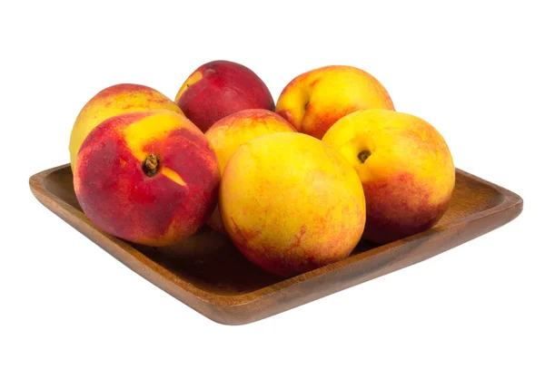 Nectarines in wooden plate — Stock Photo, Image