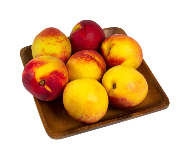 Nectarines in wooden plate — Stock Photo, Image