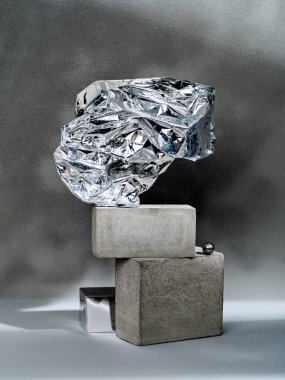 Kozmetik ürünlerin gösterimi için soyut bir arkaplan. Beton geometrik şekilli ve buruşuk alüminyum folyolu sahne. Ürün sunumu için boş vitrin. 