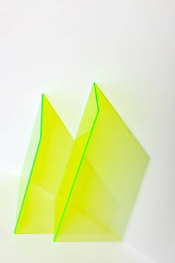 Parlak beyaz bir zemin üzerinde neon sarısı akrilik şekiller. Reklam, tanıtım ve sergi için renkli minimalist bir aşama. Metin için alanı olan soyut arkaplan. 