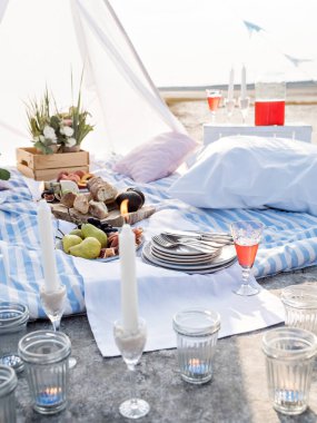 Yaz kahvaltısı ya da arkadaşlar için deniz kıyısında düzenlenen akşam yemeği. Romantik randevu için şık bir yer. Güneş çiçekleri, meyveler, peynir ve ekmek atıştırmalıklar, mumlar. Şenlikli ve şık sofra takımı..