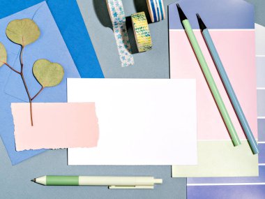 Öğrenci, sanatçı renk örnekleri ve ofis malzemeleriyle dalga geçiyor. Bağımsız yaratıcıların iş yeri. Planlayıcı, liste, eskiz defteri, ruh hali tahtası. Ev kavramından çalış.