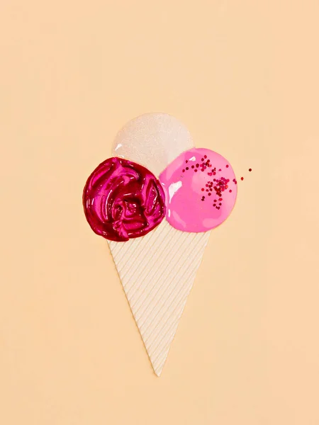 Shiny colourful lip gloss of pink colours composed in shape of ice-cream cone. Summer vibes. Minimalist creative concept of cooling and refreshing makeup.