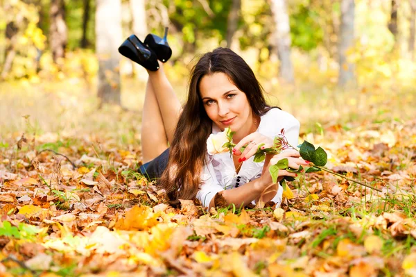 Žena leží na podzimní listí — Stock fotografie
