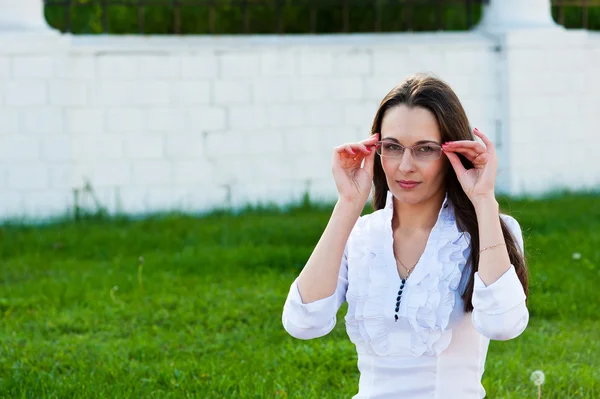 Mujer de negocios sostiene gafas — Foto de Stock