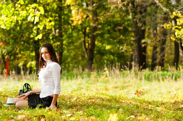 Genç kız çimenlerde oturuyor. — Stok fotoğraf
