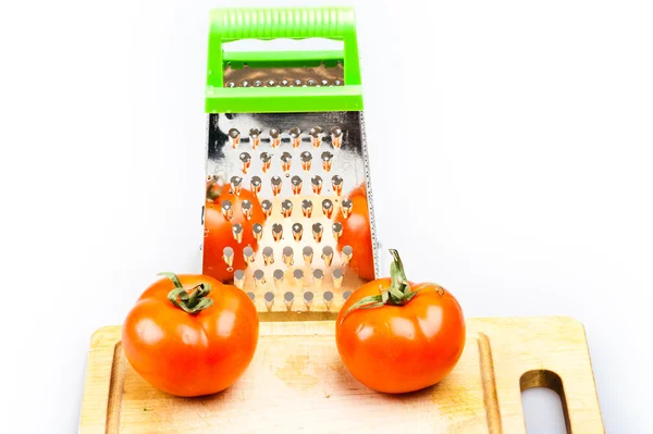 Grater with tomatoes on isolated on white — Stock Photo, Image