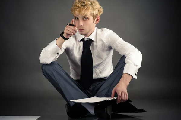 Uomo d'affari fare una scelta mentre seduto sul pavimento — Foto Stock