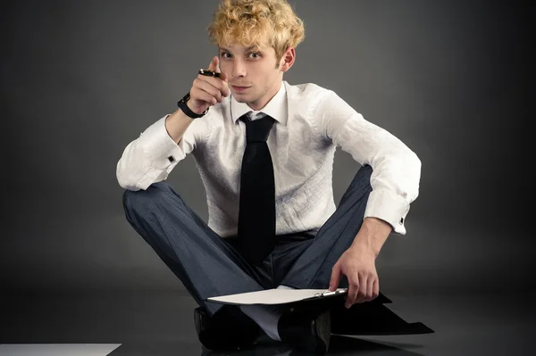 Businessman making a choice while sitting on the floor — Stock Photo, Image