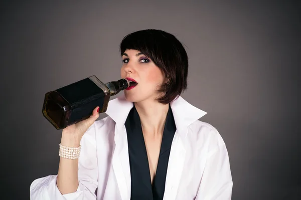 Woman in a man's shirt is drinking from a bottle — Stock Photo, Image