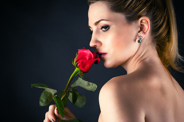 Portrait of beautiful woman smelling a rose