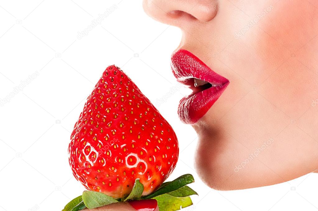 Sexy woman eating strawberry