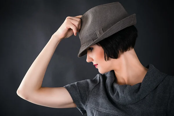 Rostro de una hermosa mujer con un sombrero masculino — Foto de Stock