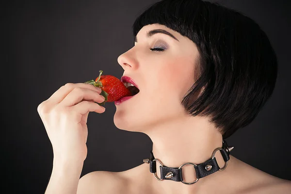 Retrato de una mujer con fresa en la boca — Foto de Stock