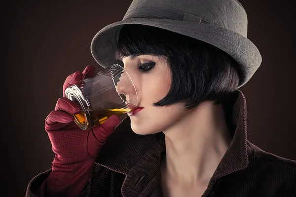 Femme détective buvant du whisky dans un verre — Photo