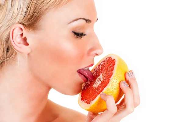 Vrouw likt grapefruit pulp — Stockfoto