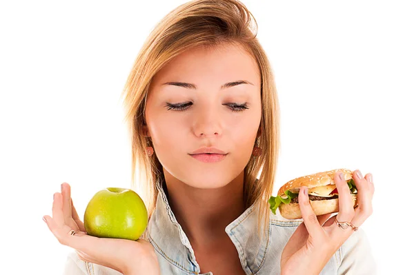 Mujer eligiendo entre manzana y hamburguesa — Foto de Stock