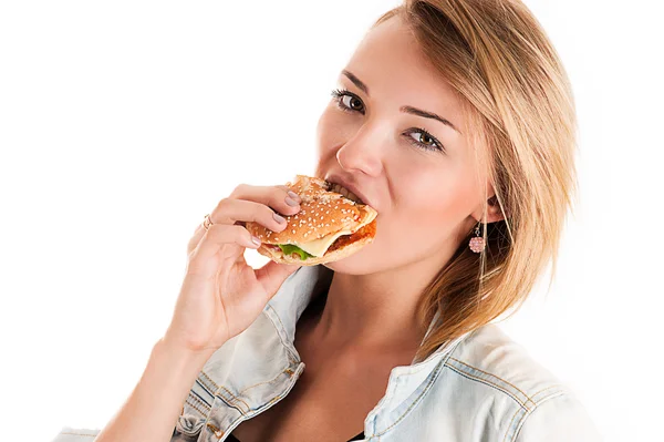 Νεαρή γυναίκα τρώει ένα χάμπουργκερ — Φωτογραφία Αρχείου