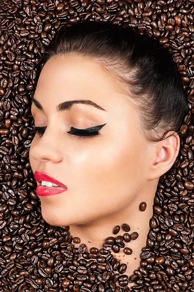 Face with closed eyes in the coffee beans — Stock Photo, Image