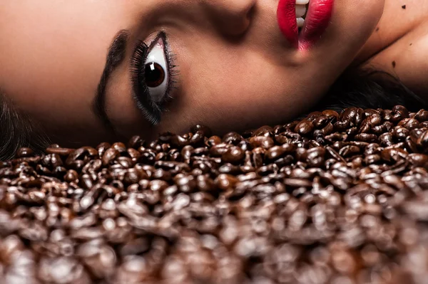 Woman's face with coffee beans — Stock Photo, Image