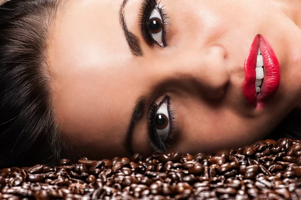 Woman face with coffee beans — Stock Photo, Image