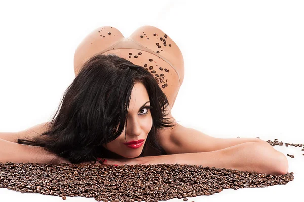 Mujer acostada con granos de café — Foto de Stock