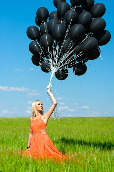 Woman looking up at the black balloons — Stock Photo, Image
