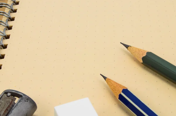 两个木制铅笔、 橡皮擦、 卷笔刀回收笔记本背景上. — 图库照片