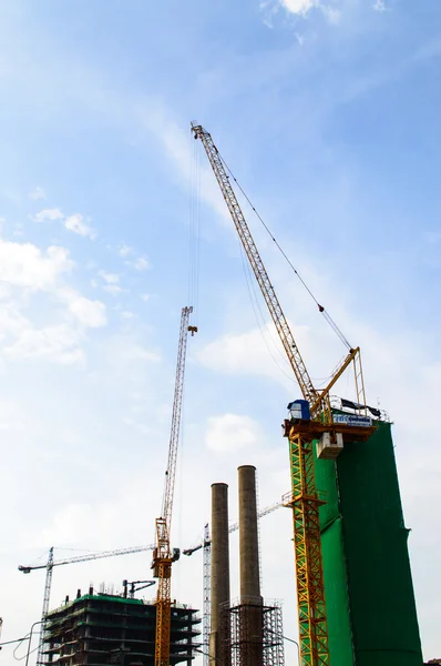 Sitio de construcción con grúa cerca de la construcción en el cielo azul backgrou — Foto de Stock