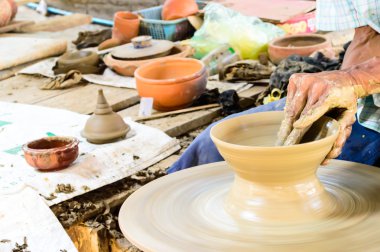 Potter's tekerlek ve usta eller bir sürahi tutun.