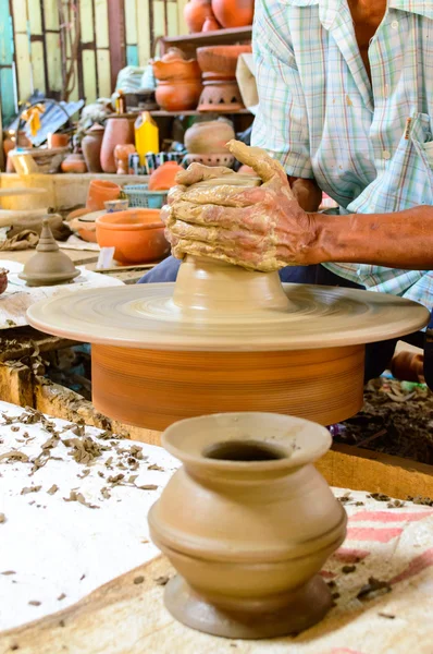 Potter's wheel and hands of craftsman hold a jug. — Stock Photo, Image