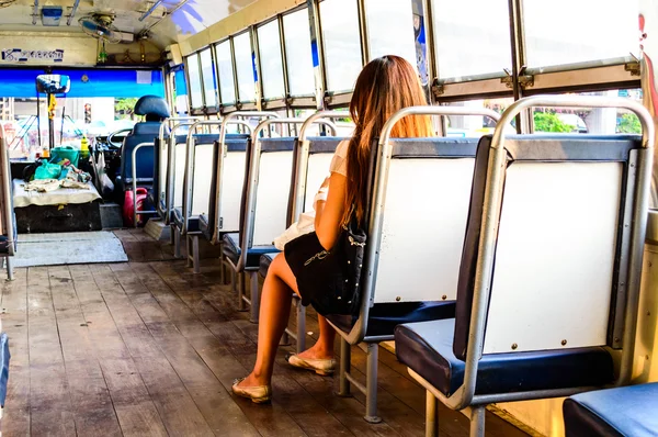 Women seat on Open Air Public bus. in Bangkok, Thailand.